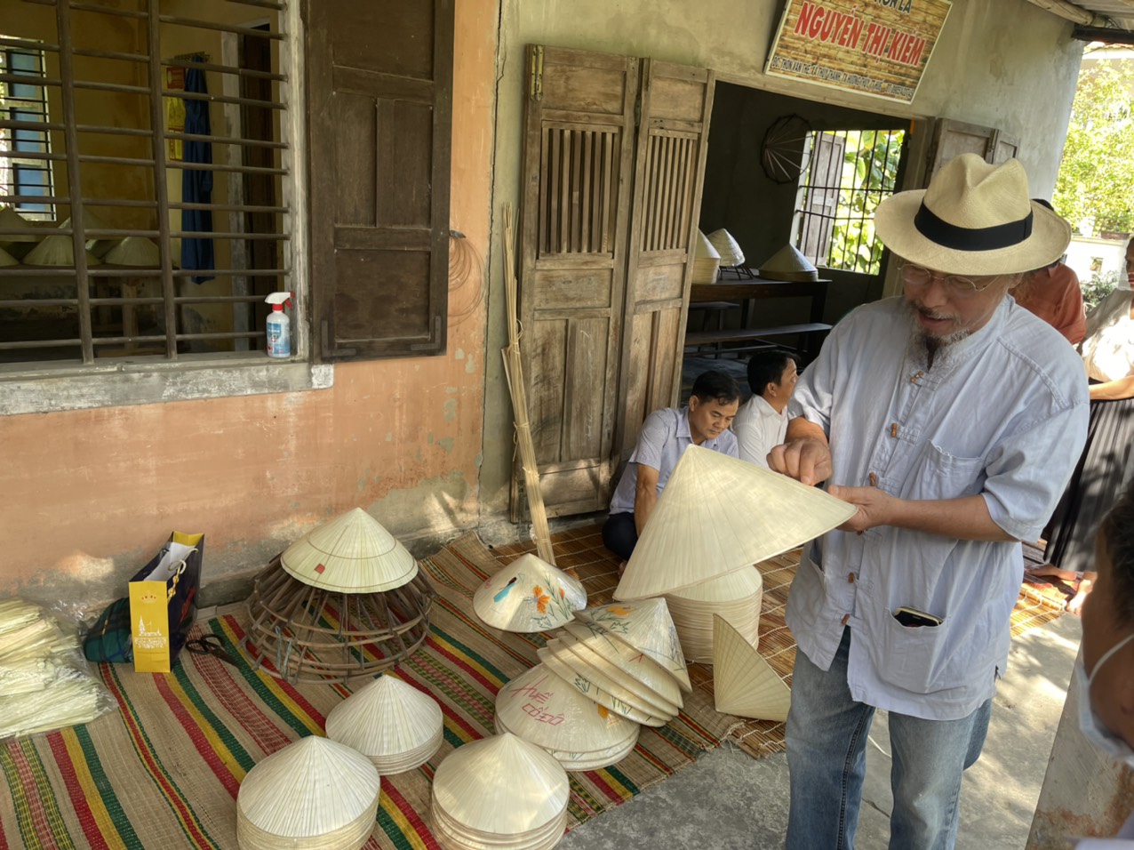 Họa sỹ Đặng Mậu Tựu góp ý, trao đổi bà con về đưa hình ảnh địa phương như Cầu ngói Thanh Toàn… trên sản phẩm nón lá làng nghề